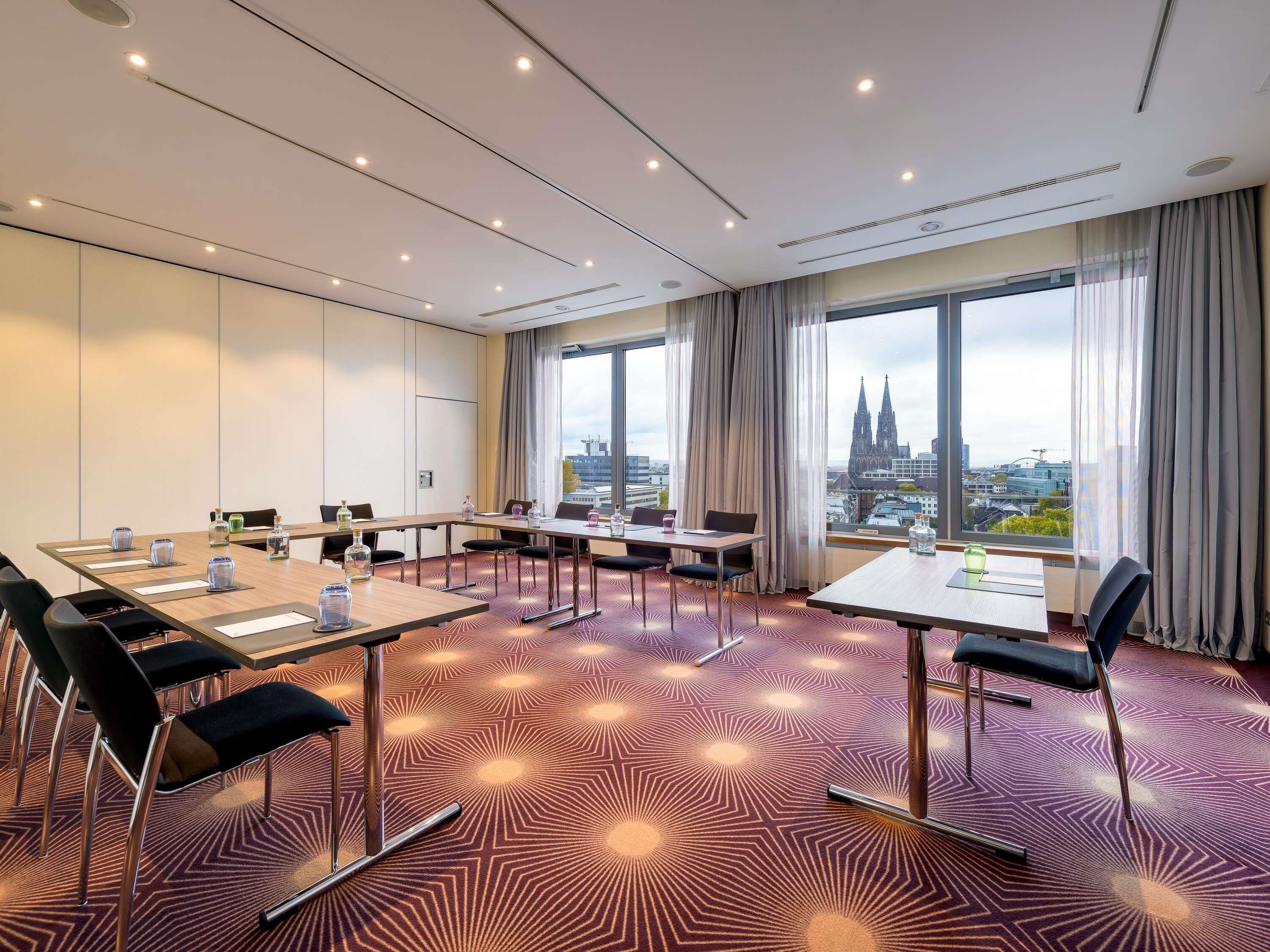 A conference room with a city view, large windows, and a patterned carpet.