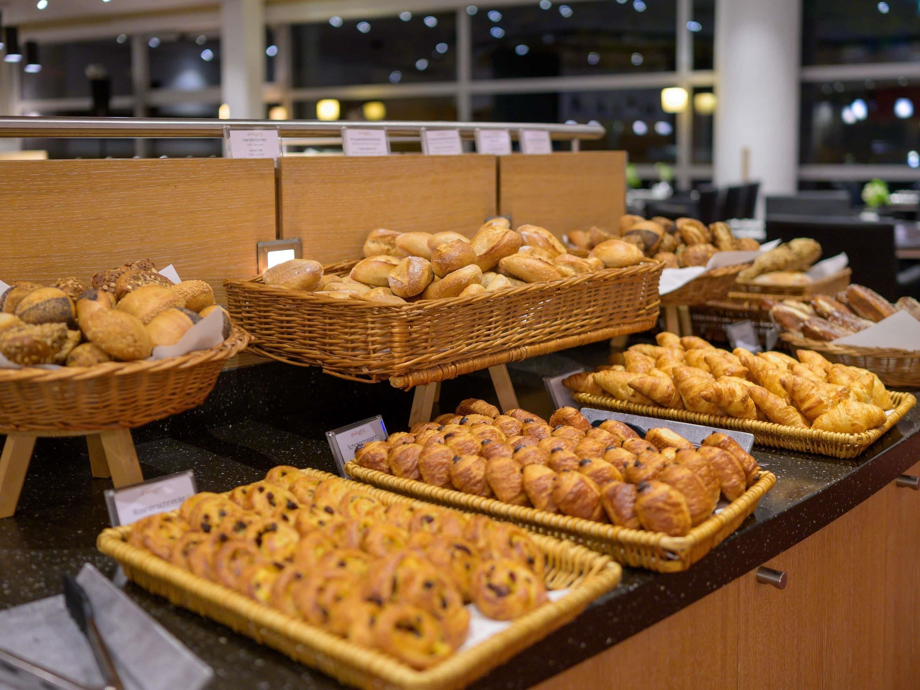 A bakery display with various types of bread and pastries.
