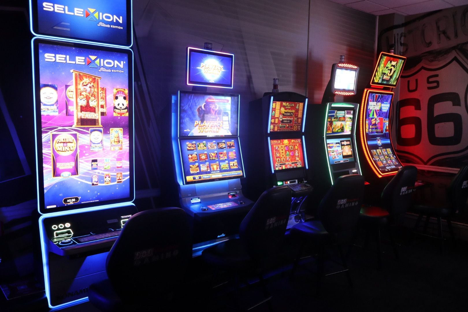 A row of slot machines with illuminated screens, one prominently displaying 'SELEXION' and another with 'Players World'.