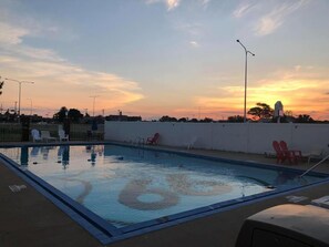 Una piscina al aire libre de temporada, sombrillas