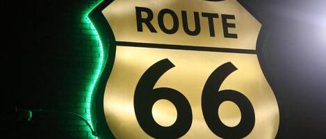 A neon sign with the text "ROUTE 66" on a brick wall.