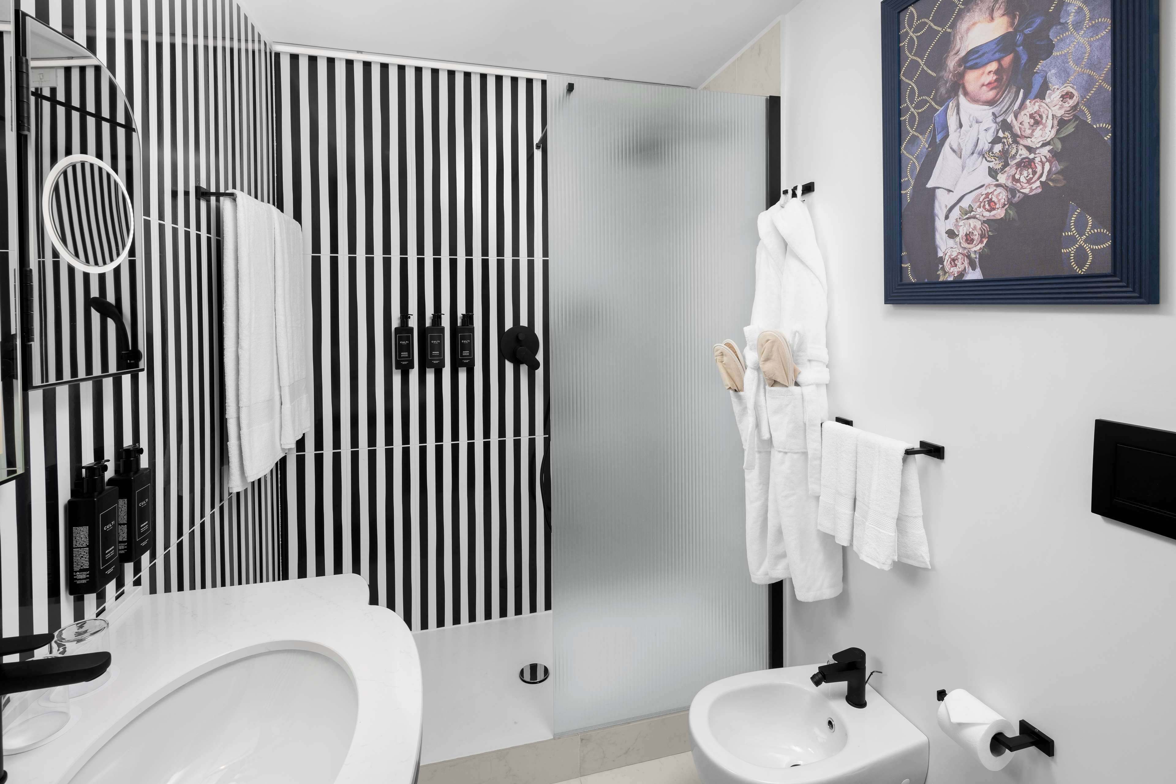 A modern bathroom with a large bathtub, a separate shower area, and a toilet.