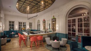 A bar area with a central island, seating arrangements, and decorative elements. - Anglo American Hotel Florence, Curio Collection by Hilton (Florence)