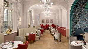 A spacious dining area with multiple tables and chairs, ornate chandeliers, and decorative wall art. - Anglo American Hotel Florence, Curio Collection by Hilton (Florence)