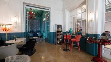 A bar area with seating, a wine cooler, and a decorative ceiling.