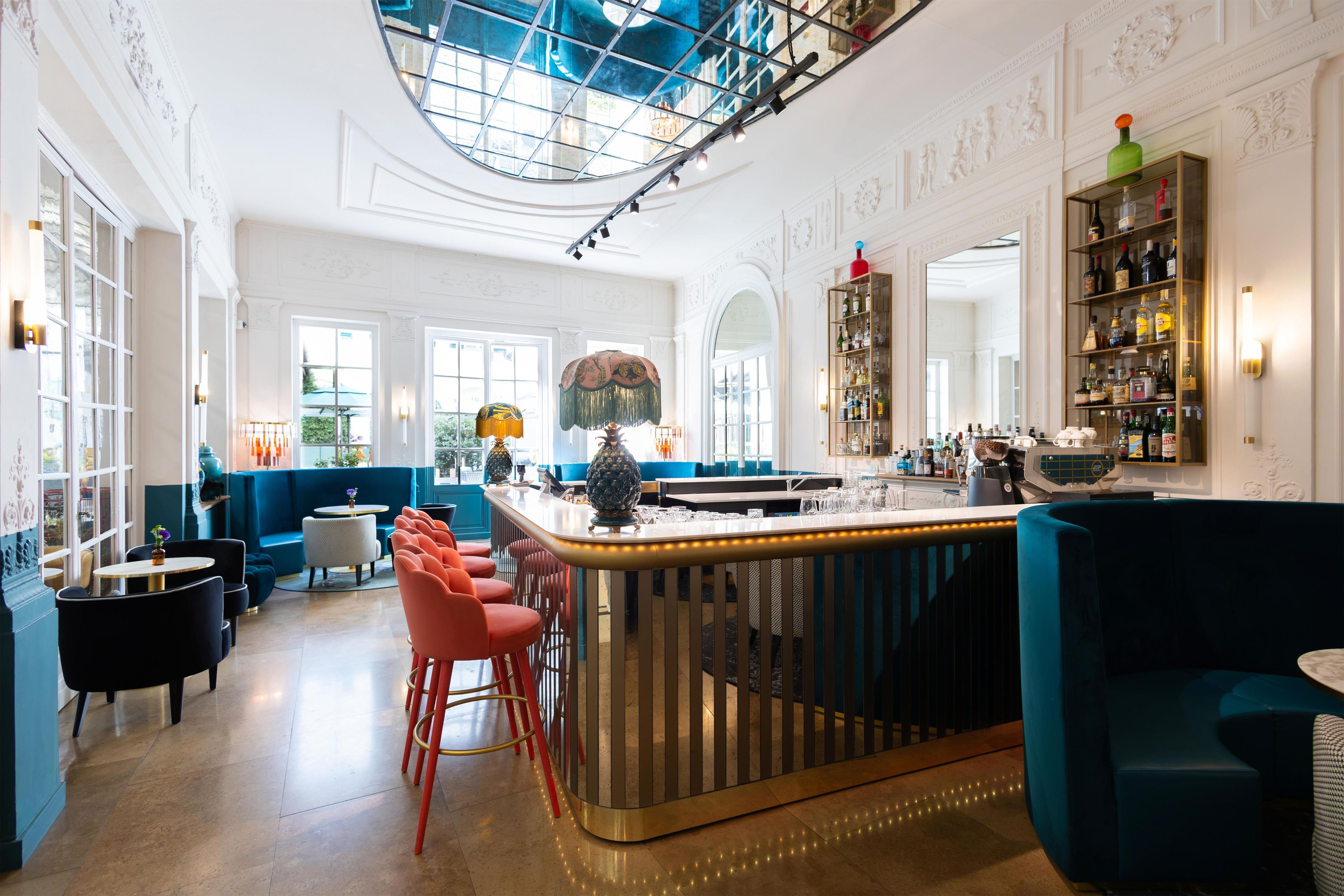 A bar area with a high ceiling, a central bar counter, and seating arrangements.