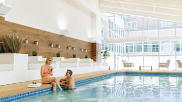 Een binnenzwembad, ligstoelen bij het zwembad