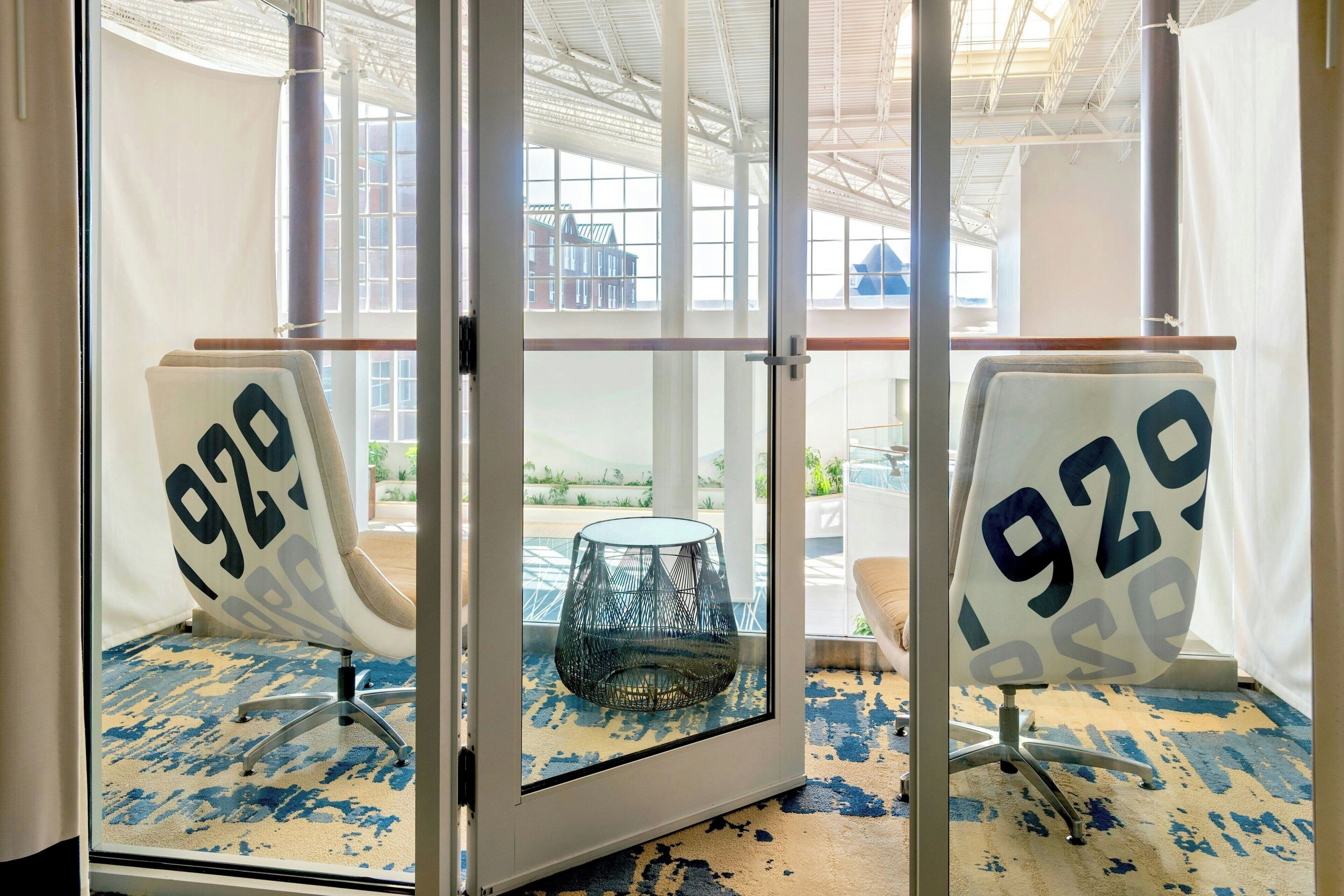 A room with two chairs labeled '929' and a glass table in the center.