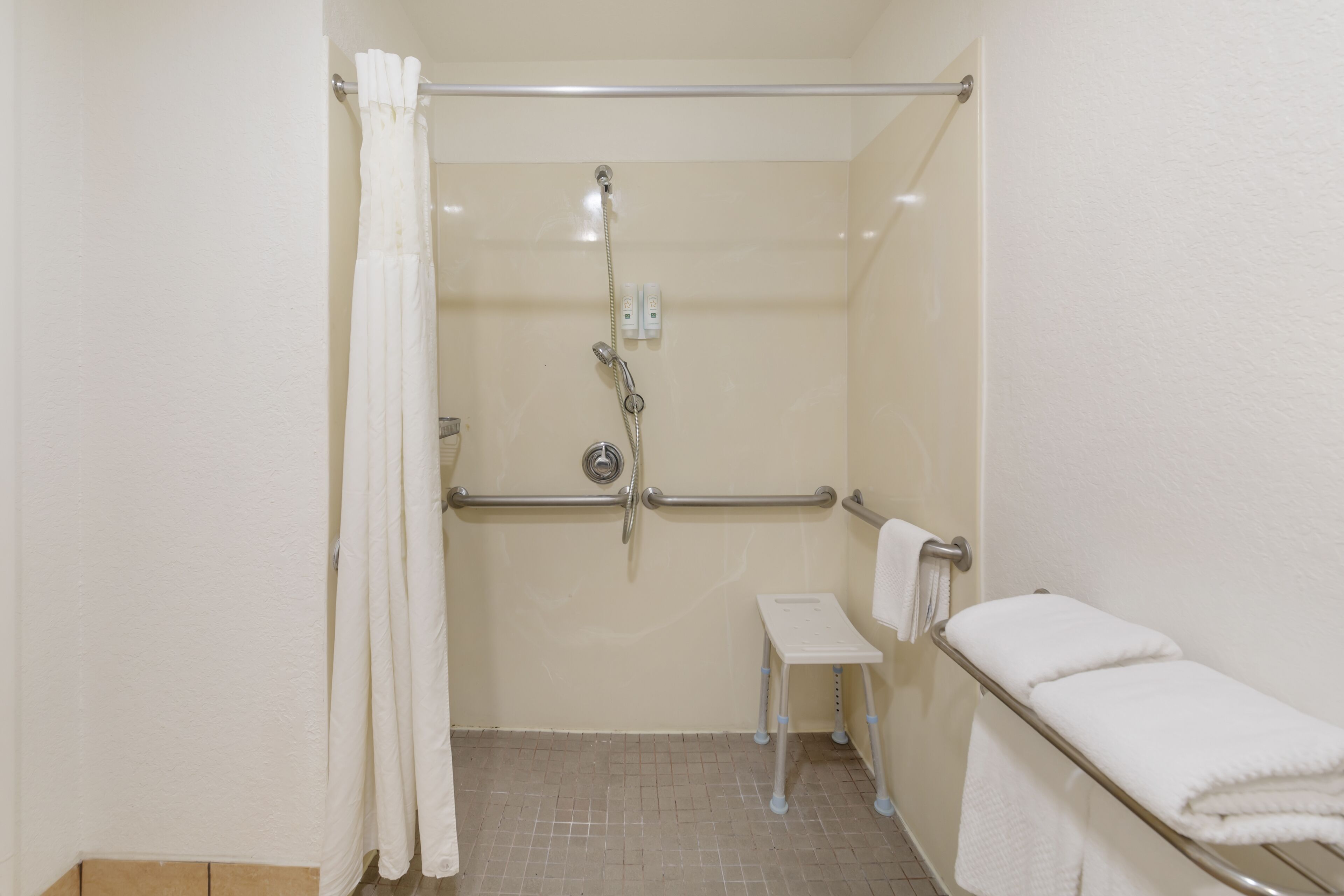 1 king bed, nonsmoking, interior corridor, accessible room, roll-in shower | bathroom | free toiletries, hair dryer, towels