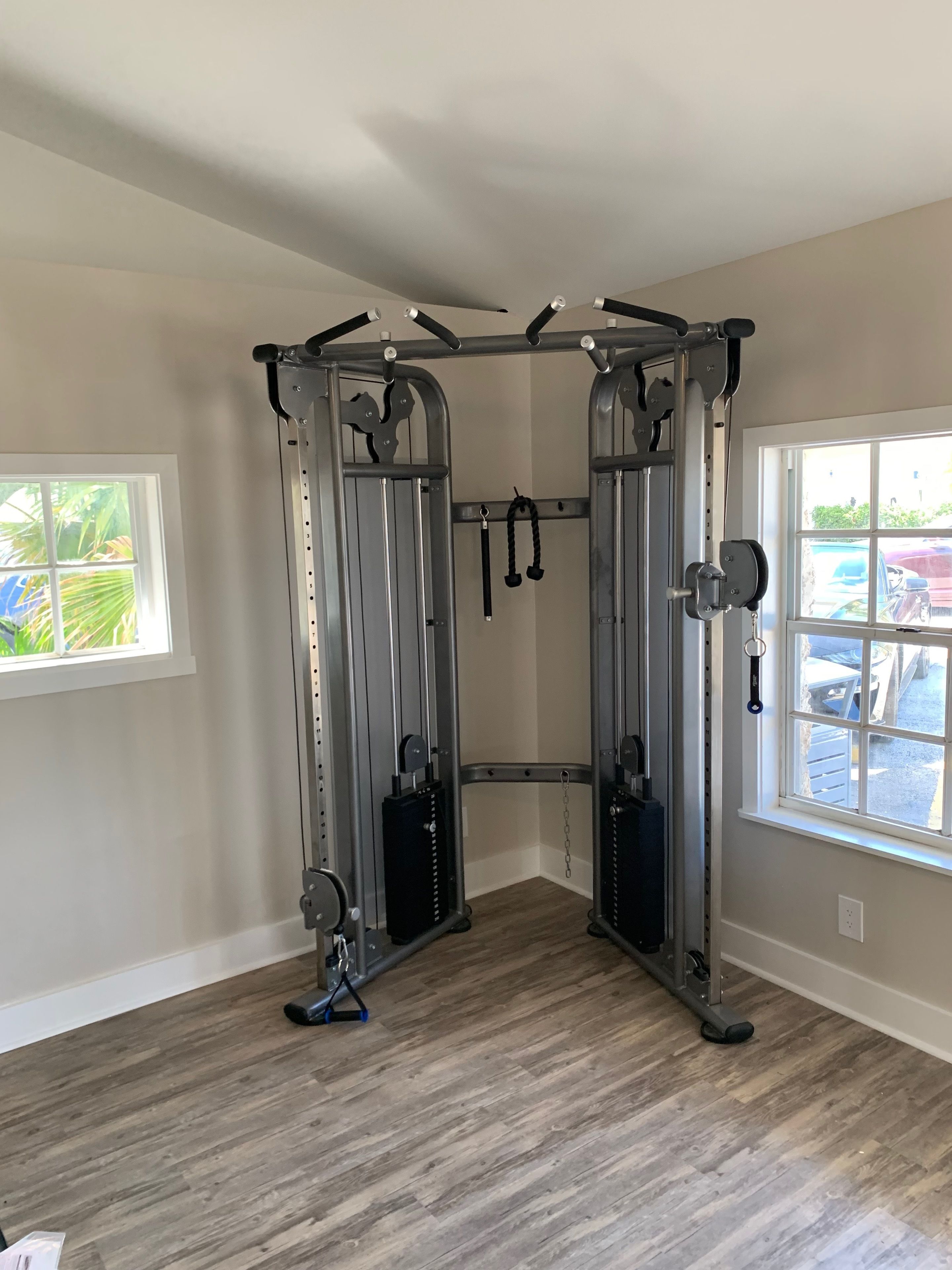 A home gym with a pull-up bar, weight bench, and resistance bands.