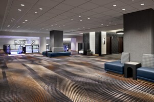 Un hall d’entrée spacieux, doté d’un tapis à motifs, de coins salon et d’un comptoir d’accueil.