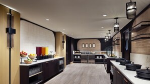 Una cocina moderna con una isla central, electrodomésticos integrados y una variedad de alimentos a la vista.