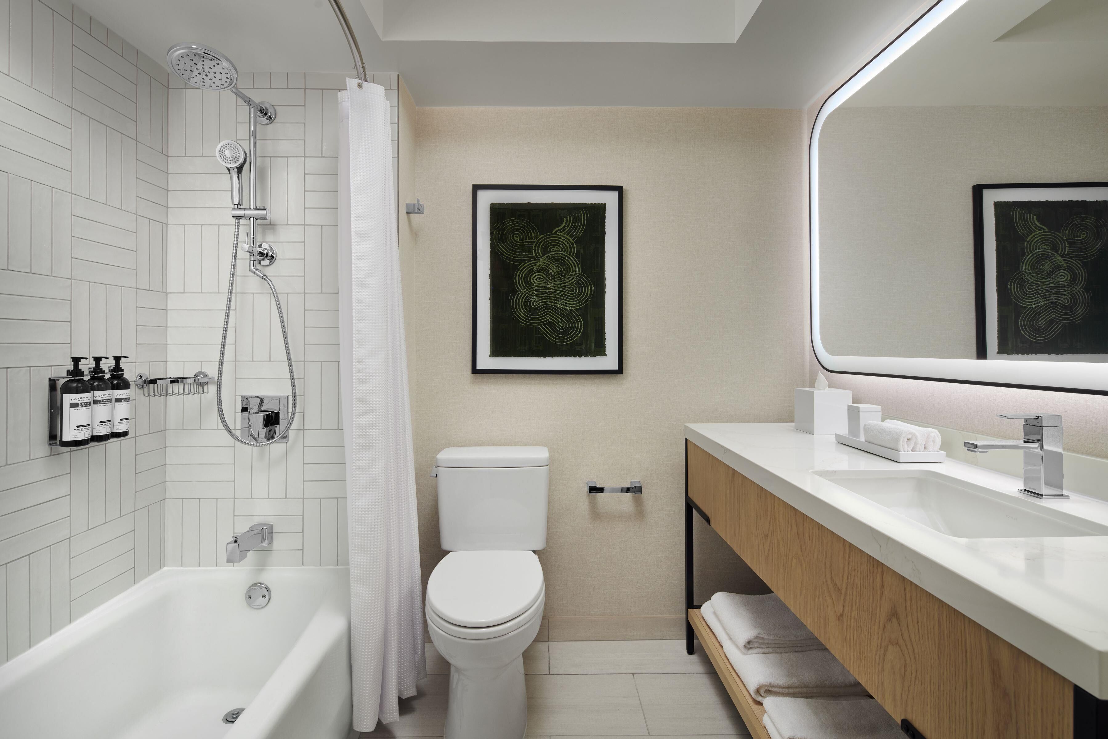 A modern bathroom with a bathtub, toilet, and vanity.
