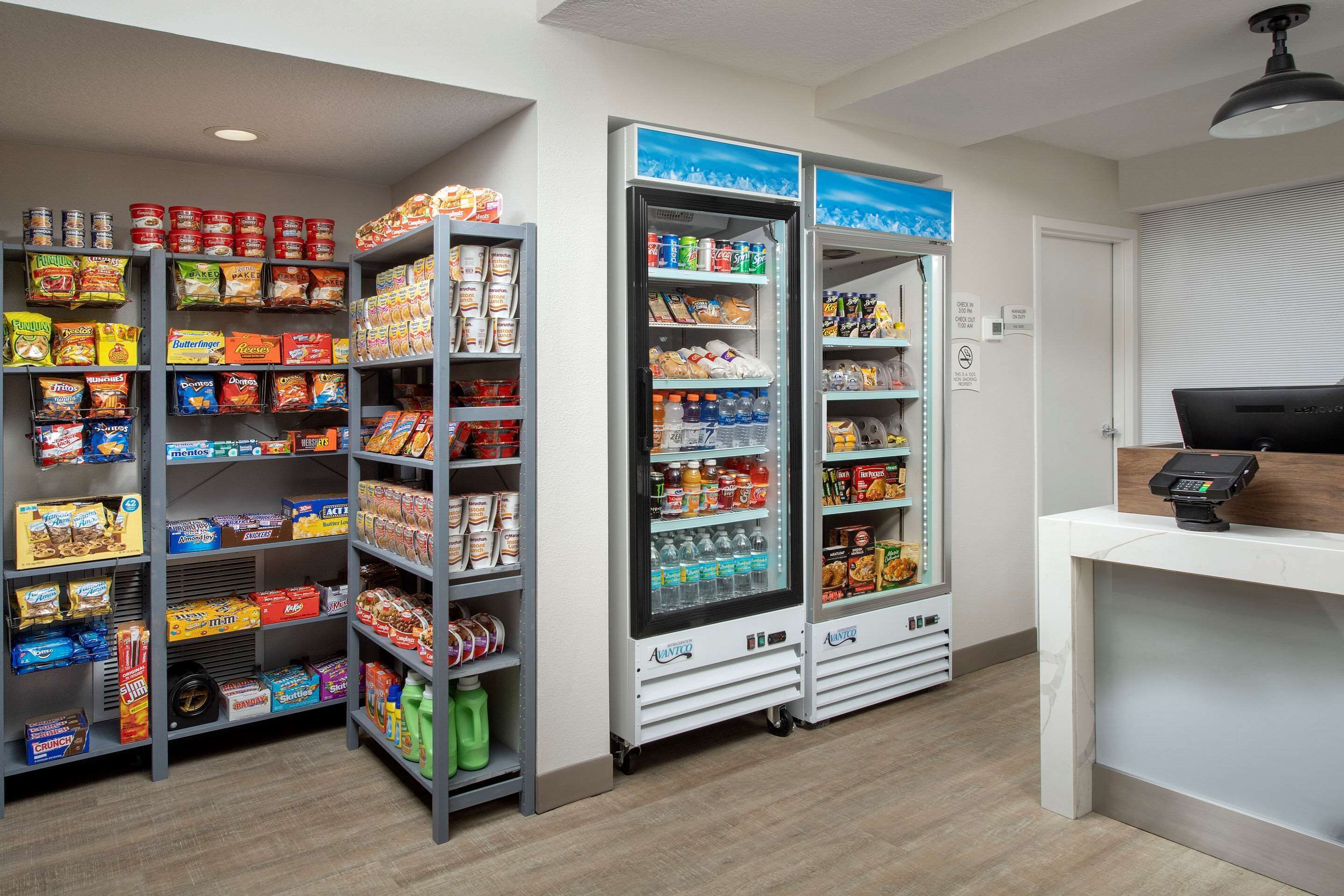 Ein Selbstbedienungsbereich für Snacks und Getränke mit mehreren Regalen, gefüllt mit einer Auswahl an Snacks und Getränken.