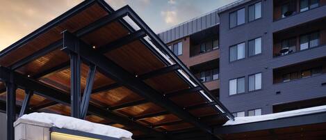 Hotel Alpen Rock with a modern entrance, wooden beams, and a snowy setting.