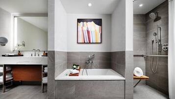 A modern bathroom with a freestanding bathtub, a shower, and a large mirror.