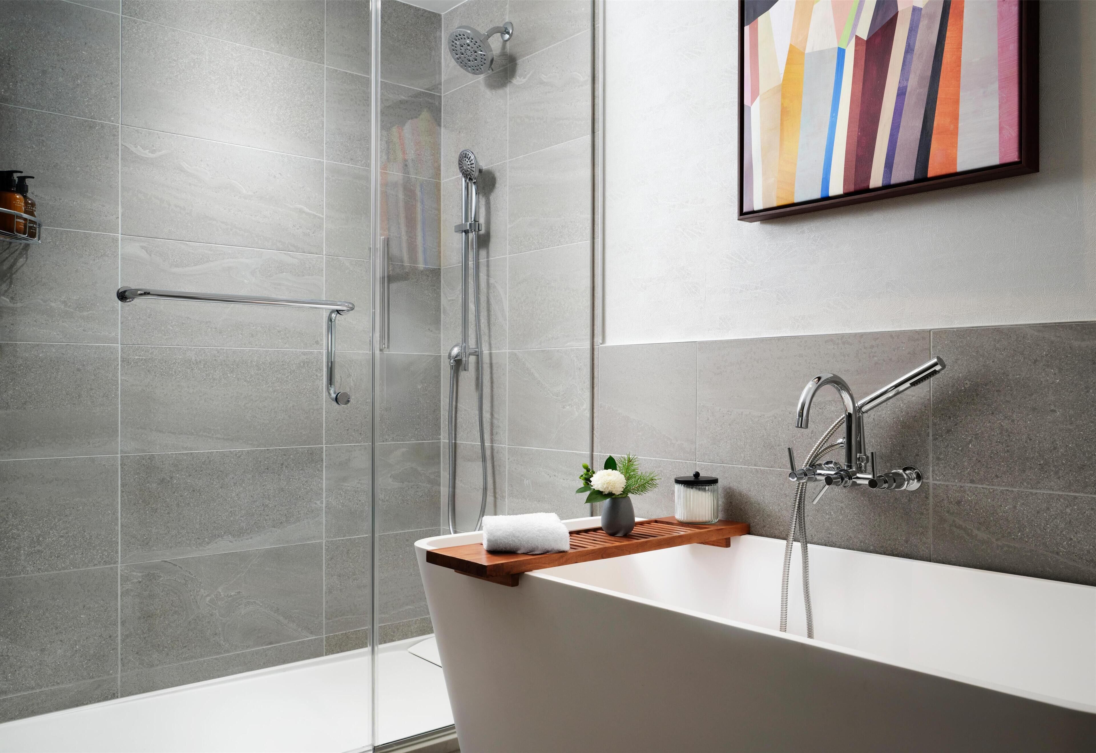 Une salle de bain moderne avec une baignoire sur pieds, un espace douche et une paroi de douche en verre.