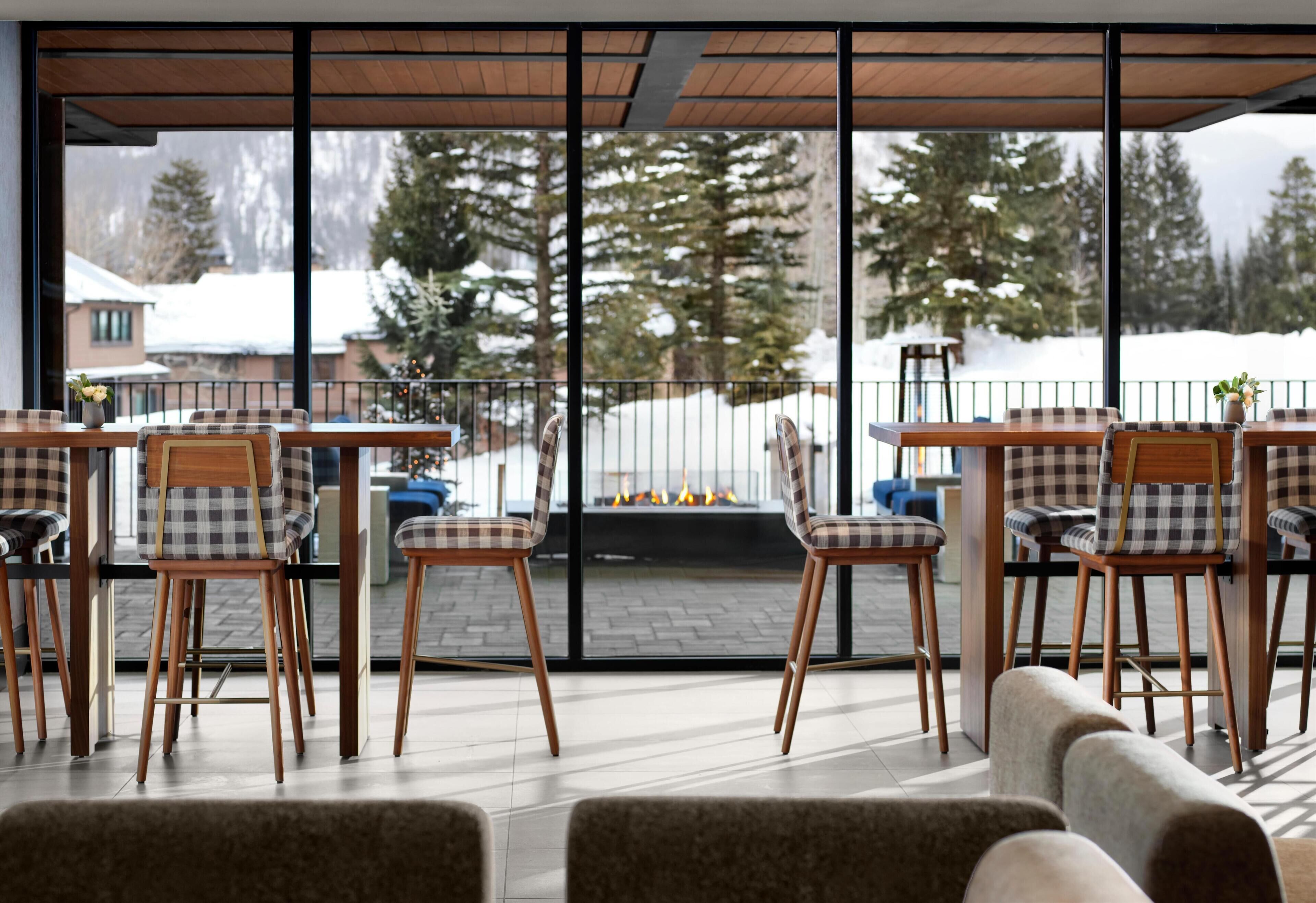 A modern indoor seating area with a view of a snowy landscape through large windows.