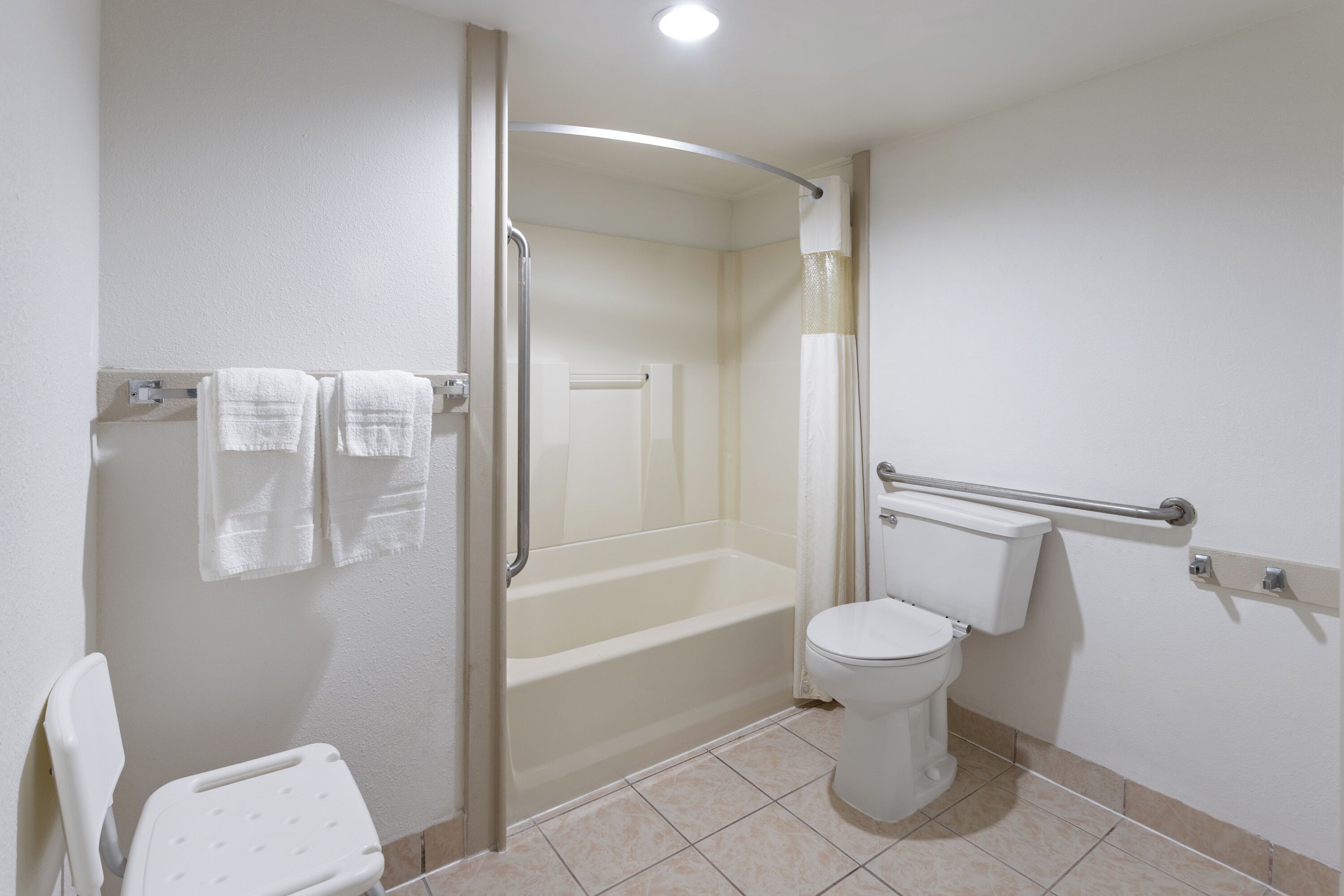 A bathroom with a bathtub, toilet, and a shower stall.