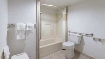 A bathroom with a bathtub, toilet, and a shower stall.