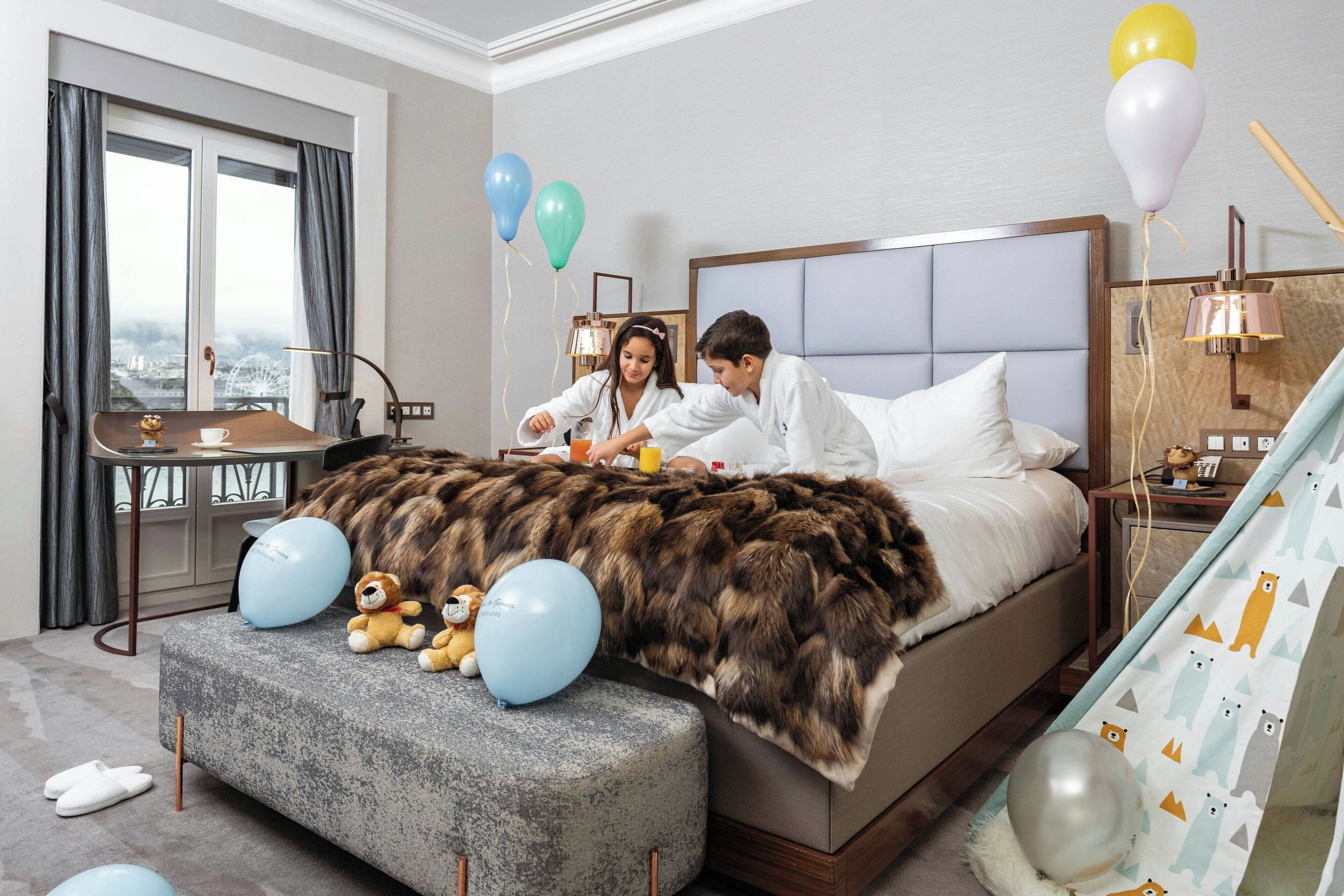 Habitación de hotel con una cama grande, una mesita y vista a una noria a través de la ventana.