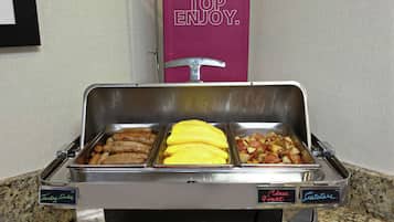 A buffet with labeled trays of food including turkey, eggs, and potatoes.