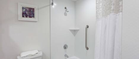 Un baño moderno con inodoro, bañera y ducha.