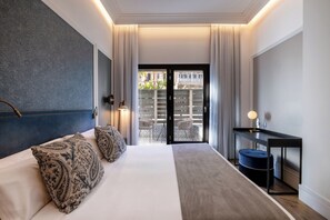 A hotel room with a bed, a desk, a chair, and a view of the outside. - Catalonia Plaza Cataluña (Barcelona)