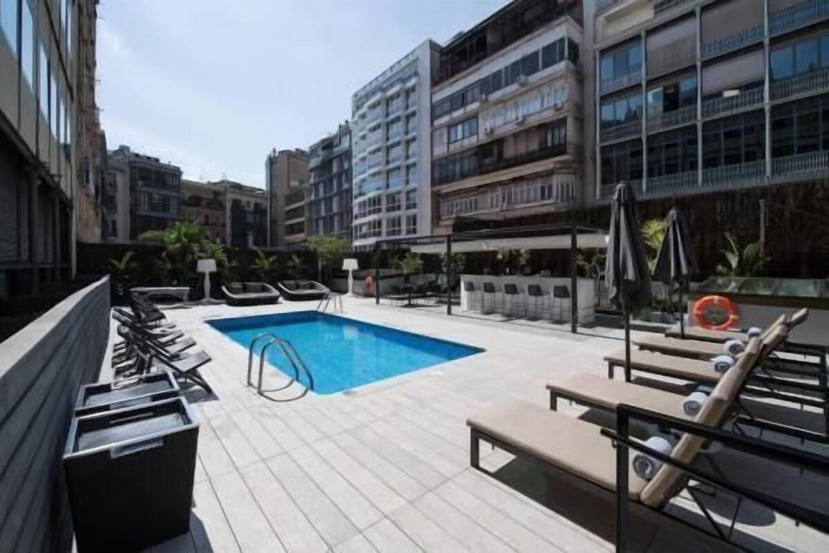 Uma área de piscina no terraço com espreguiçadeiras e piscina.
