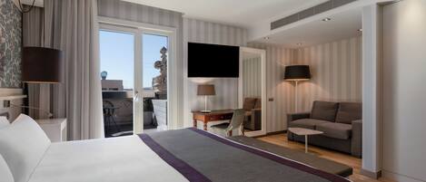 Una habitación de hotel moderna con una cama grande, un escritorio, un sofá y un televisor.