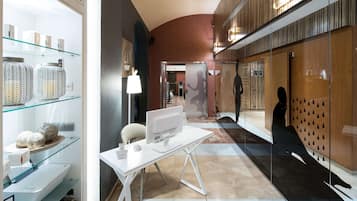 A modern hotel lobby with a white desk, glass display cases, and a wooden reception desk.