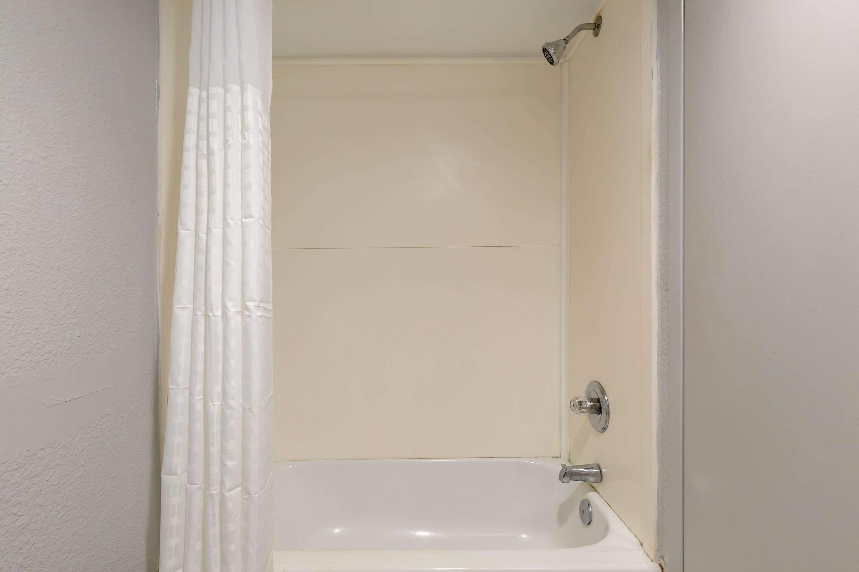 A bathroom with a bathtub, a shower, and a toilet.