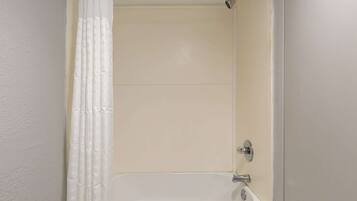A bathroom with a bathtub, a shower, and a toilet.