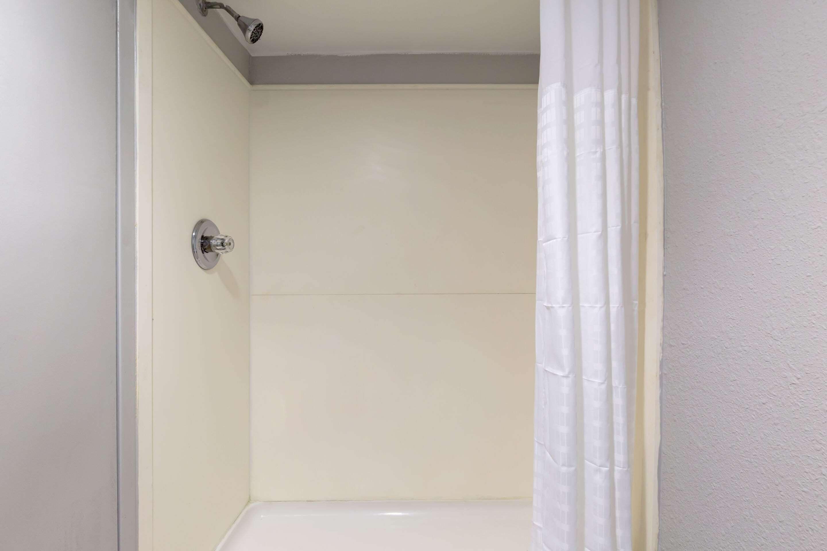 A bathroom with a shower, a toilet, and a sink.