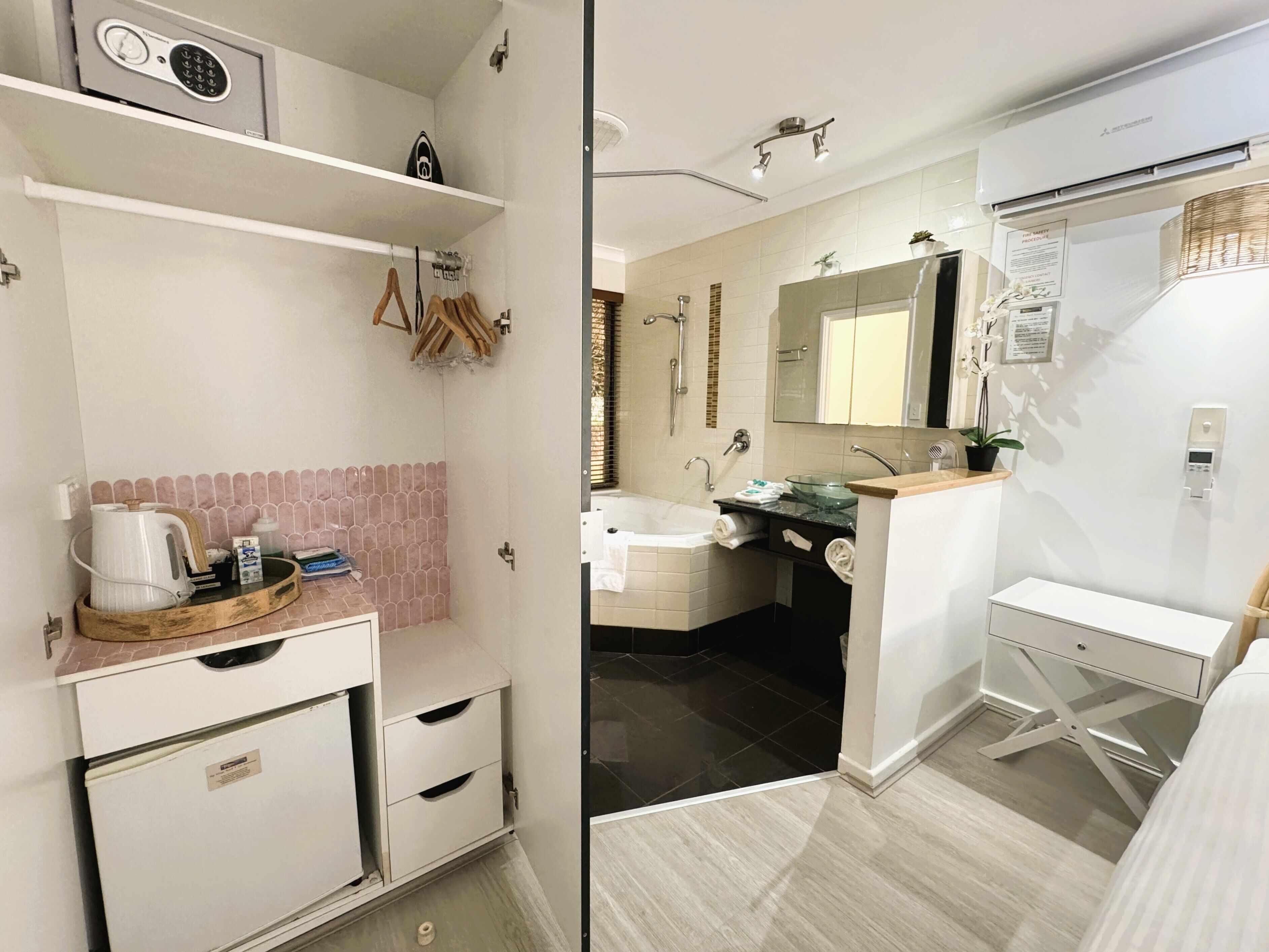 A modern bathroom with a shower, sink, and toilet. There is a towel rack, a small shelf with toiletries, and a mirror above the sink.
