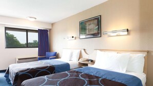 Habitación de hotel con dos camas, una ventana con cortinas, un cuadro en la pared y una lámpara de noche.
