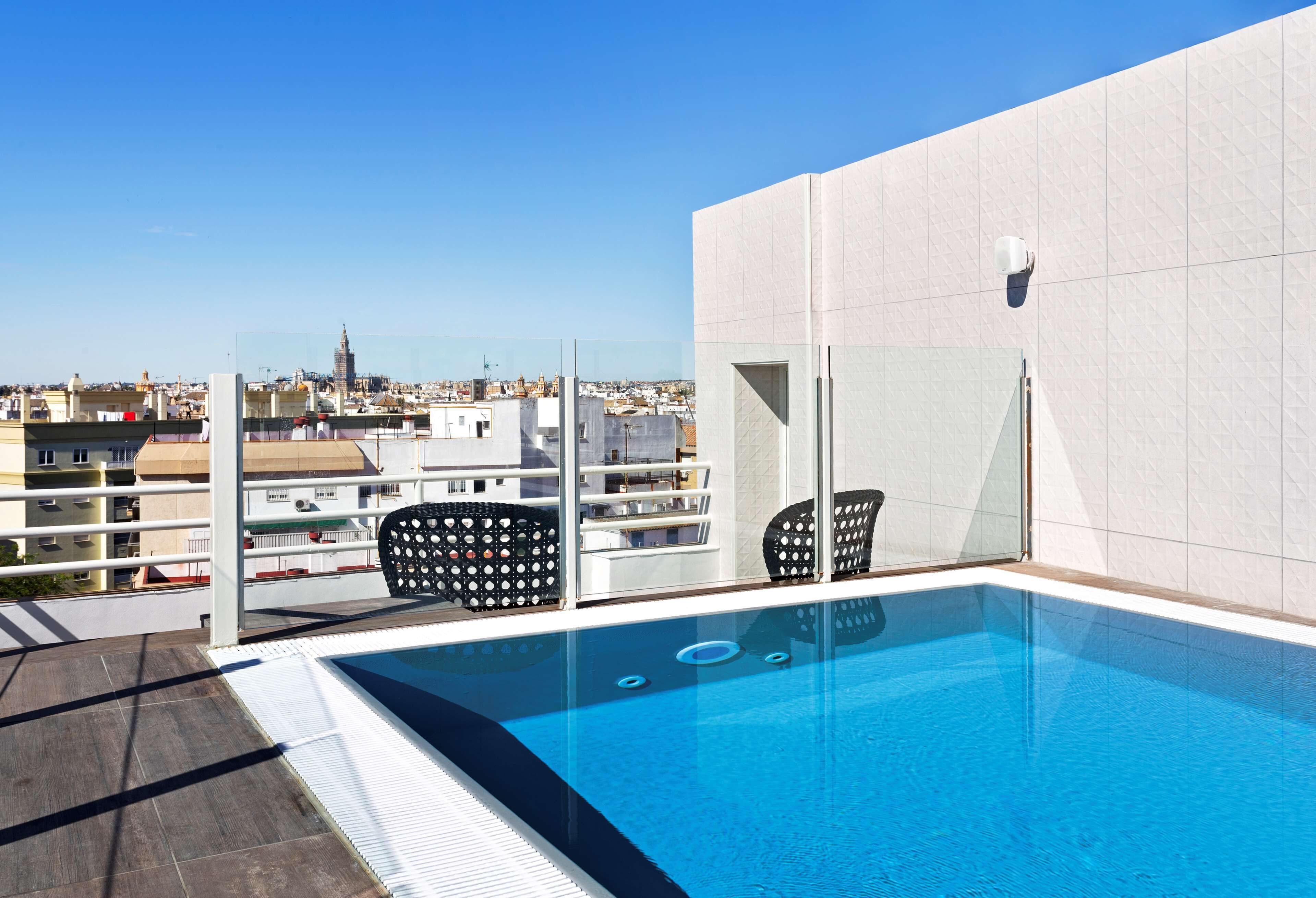 A rooftop pool with a clear view of the cityscape, including a prominent tower.