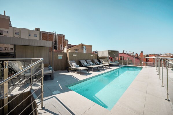 Alberca al aire libre y camastros 