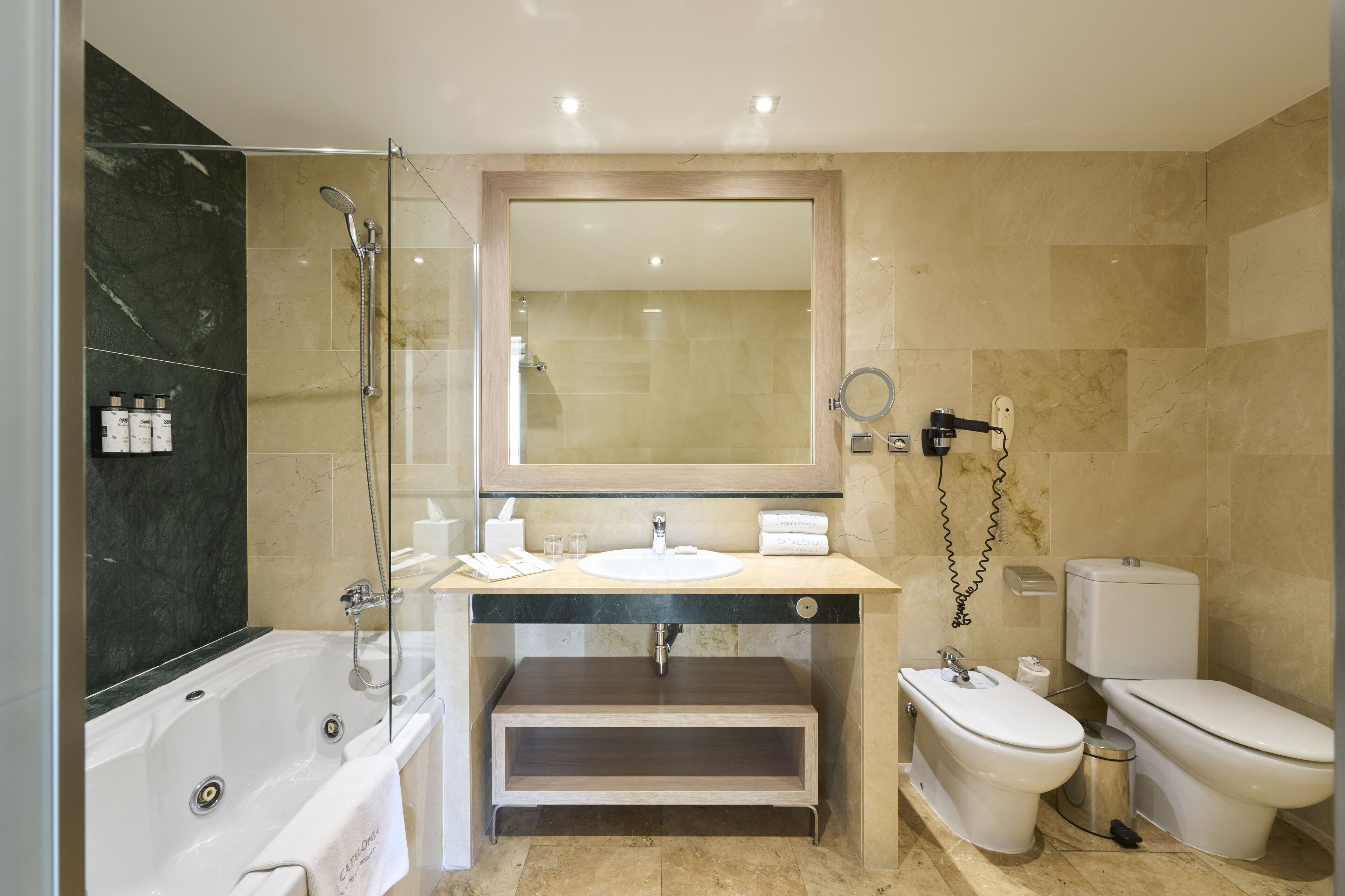 A modern bathroom with a bathtub, a sink, a toilet, and a shower.