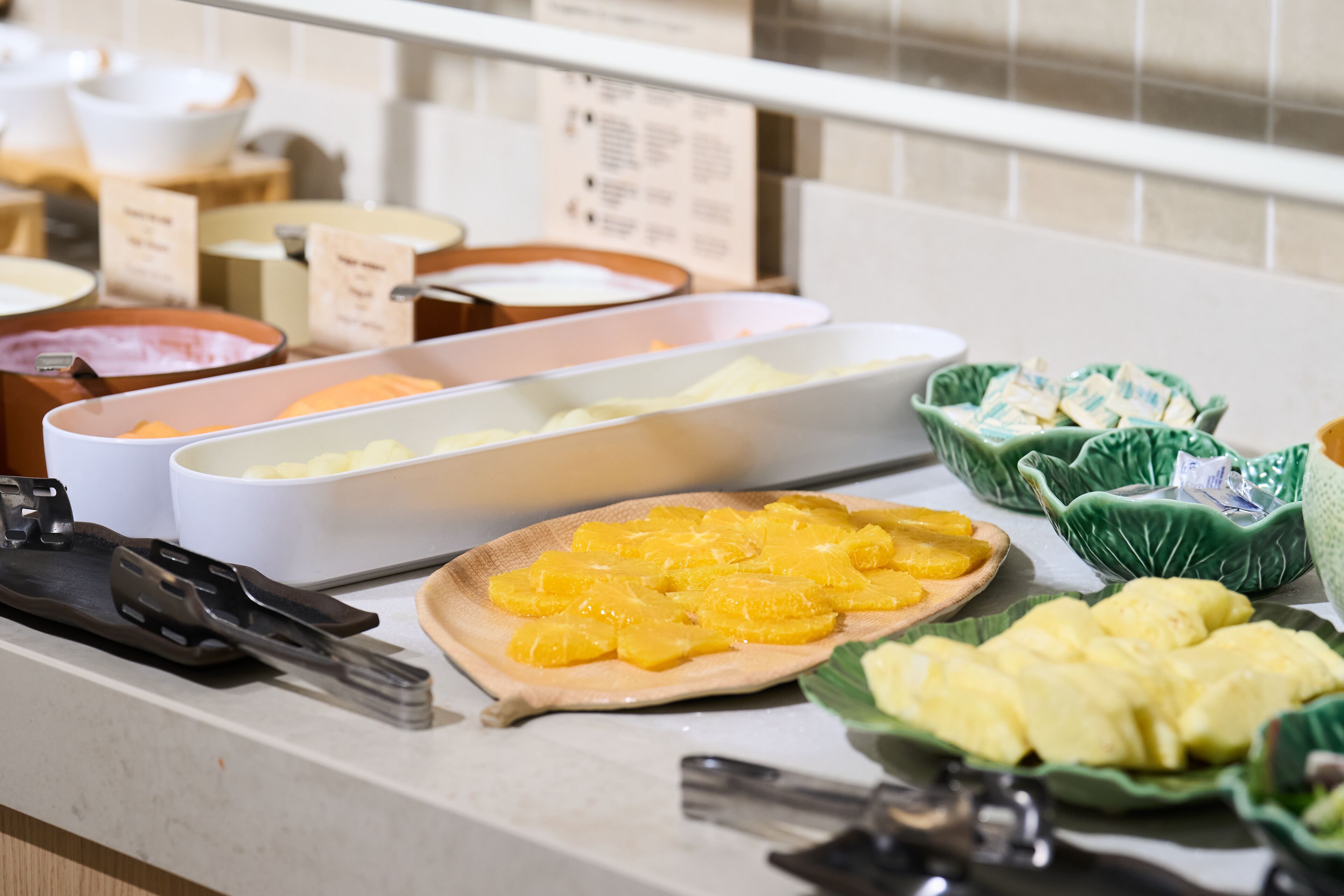 Un bufé con diversos alimentos, incluyendo frutas y postres.
