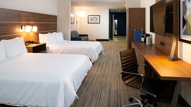 A hotel room with two beds, a desk, a chair, a TV, and a lamp. - Holiday Inn Express & Suites Los Angeles Downtown West by IHG (Los Angeles)