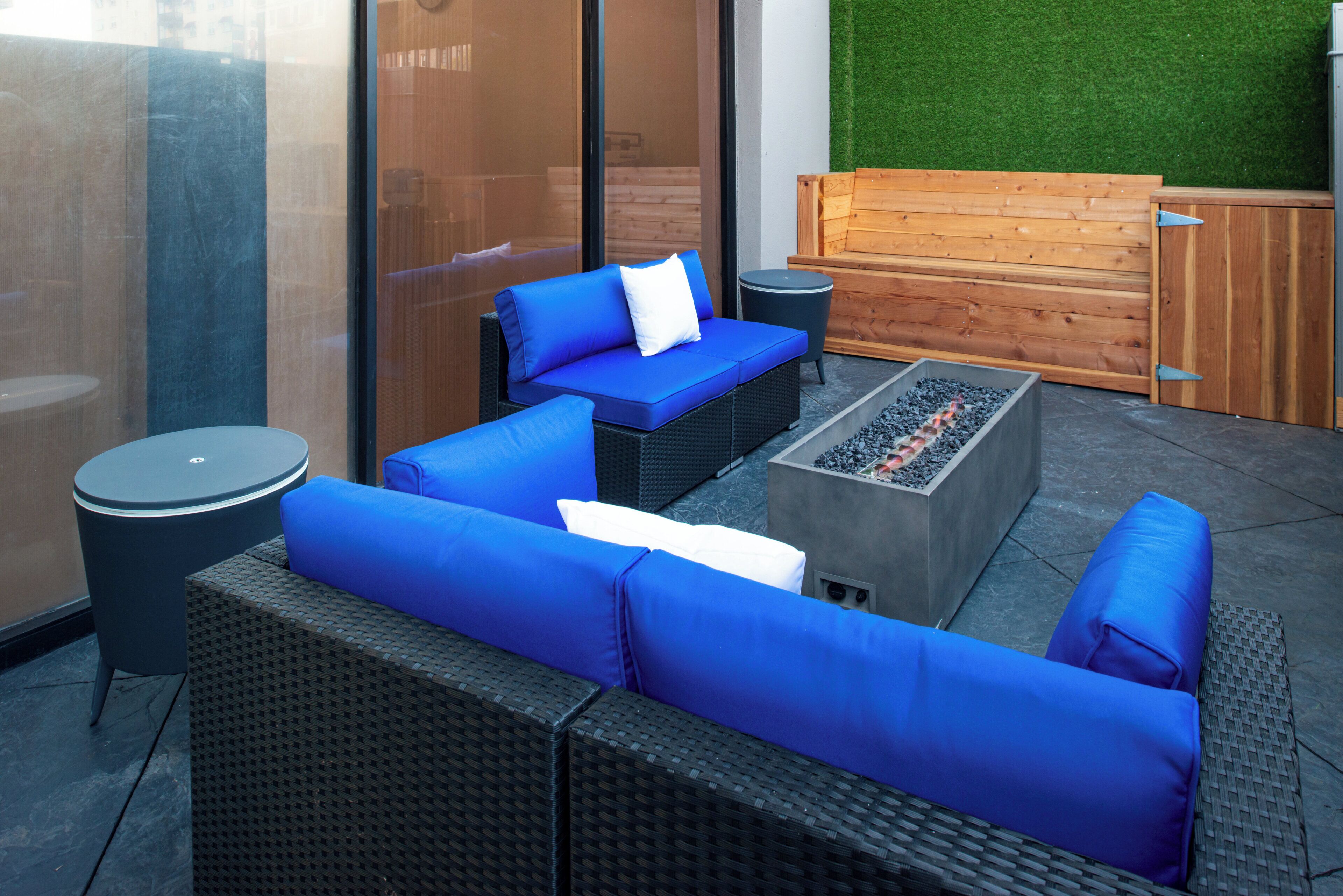 An outdoor seating area with wicker furniture and a built-in fire feature.