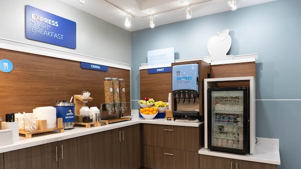 A breakfast area with a sign for 'Express Start Breakfast', a fruit display, and a yogurt dispenser. - Holiday Inn Express & Suites Los Angeles Downtown West by IHG (Los Angeles)