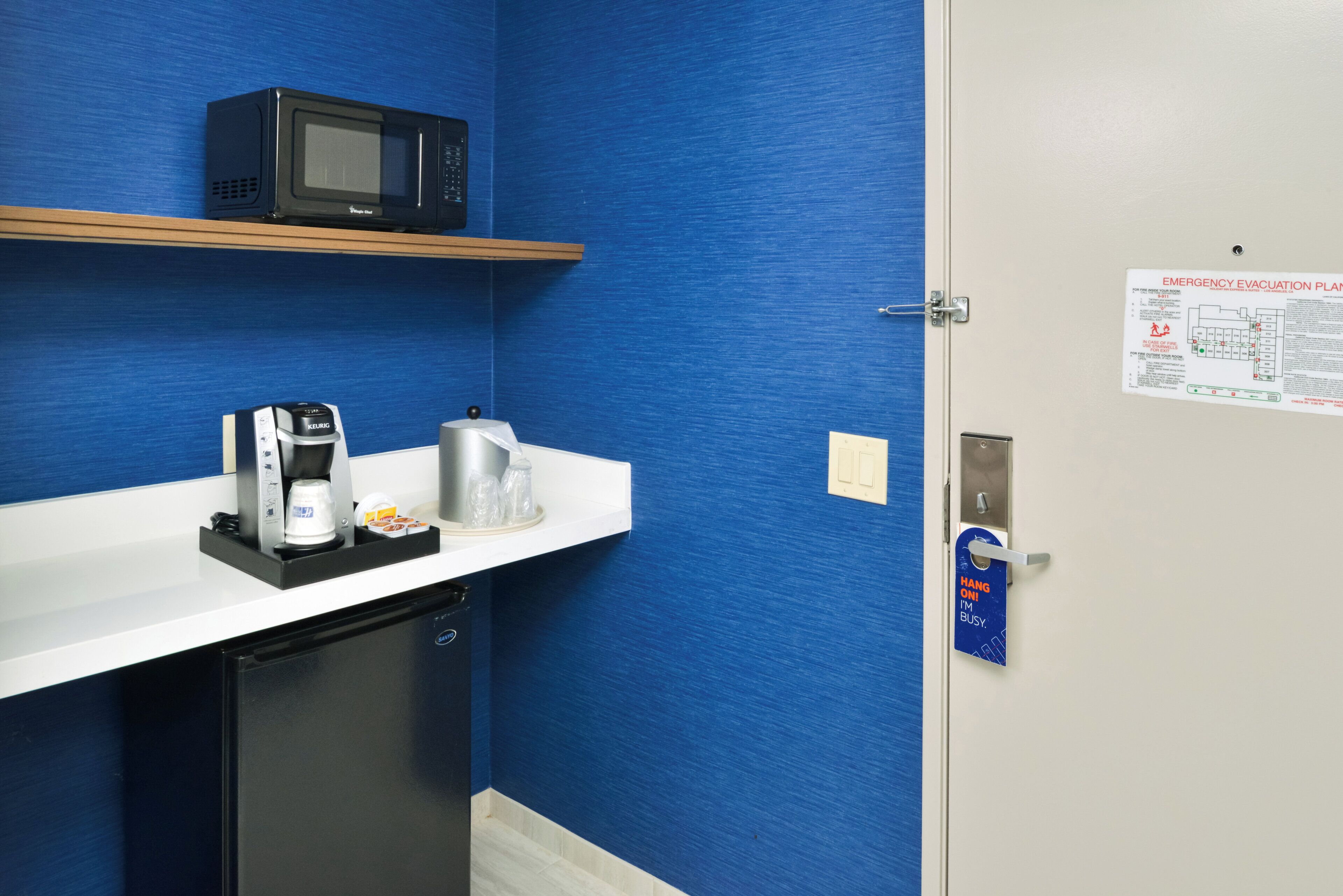 A kitchenette with a microwave, coffee machine, and a small refrigerator.