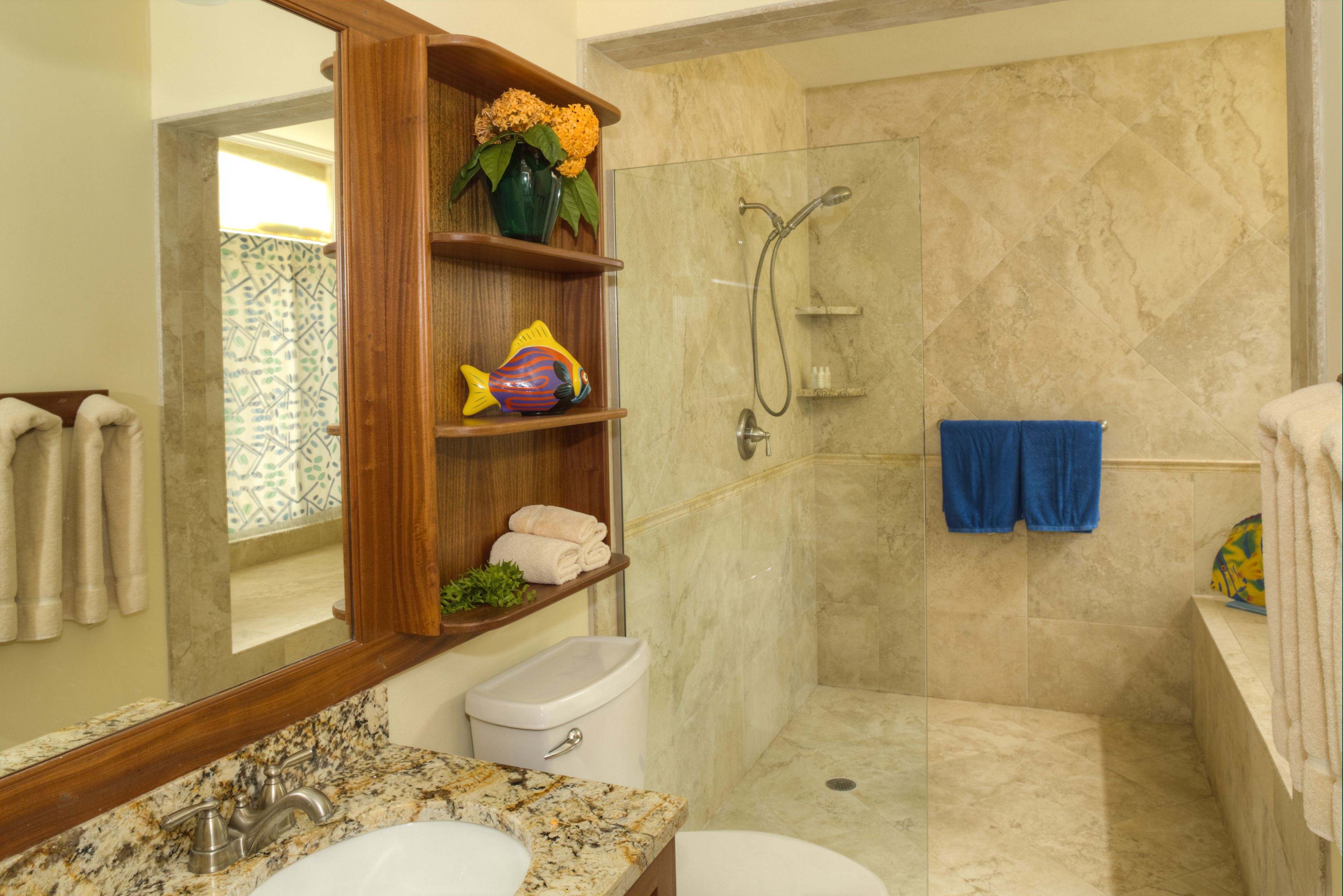 Baño con ducha de mármol, lavabo e inodoro.