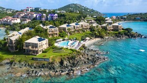 A coastal resort with multiple buildings, a swimming pool, and a rocky shoreline. - Gallows Point Resort (St. John)