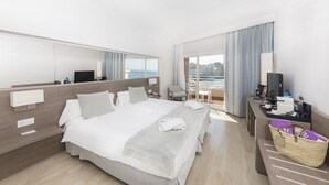 A hotel room with a large bed, a desk, a chair, a TV, and a view of the sea. - Be Live Experience Costa Palma (Palma de Mallorca)