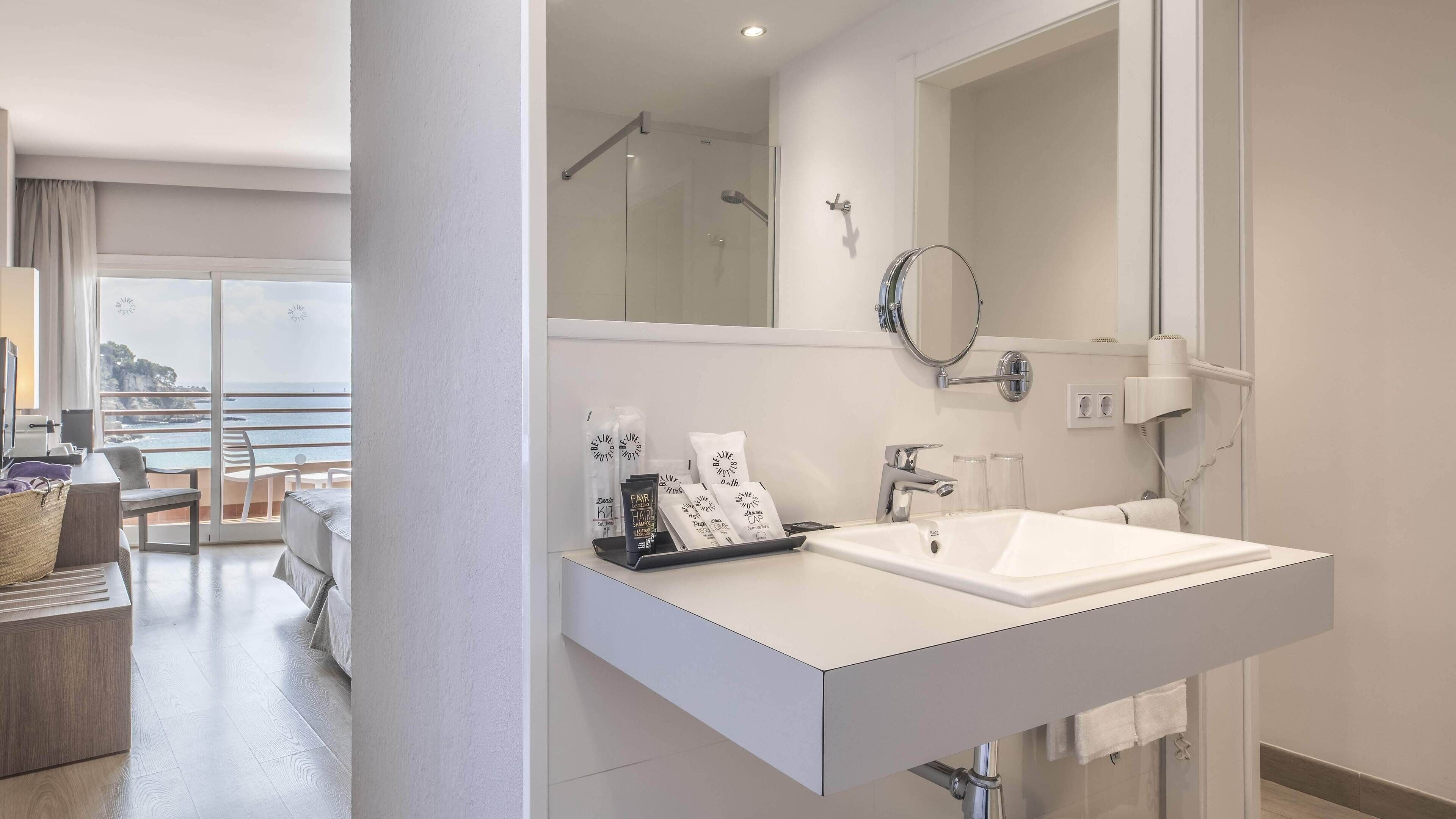 Een moderne badkamer met een grote spiegel, twee wasbakken en een douche.