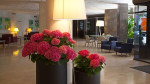 A lobby with a large floor lamp, seating area, and potted plants. - Be Live Experience Costa Palma (Palma de Mallorca)