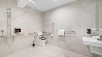 A modern bathroom with a shower, toilet, and sink.